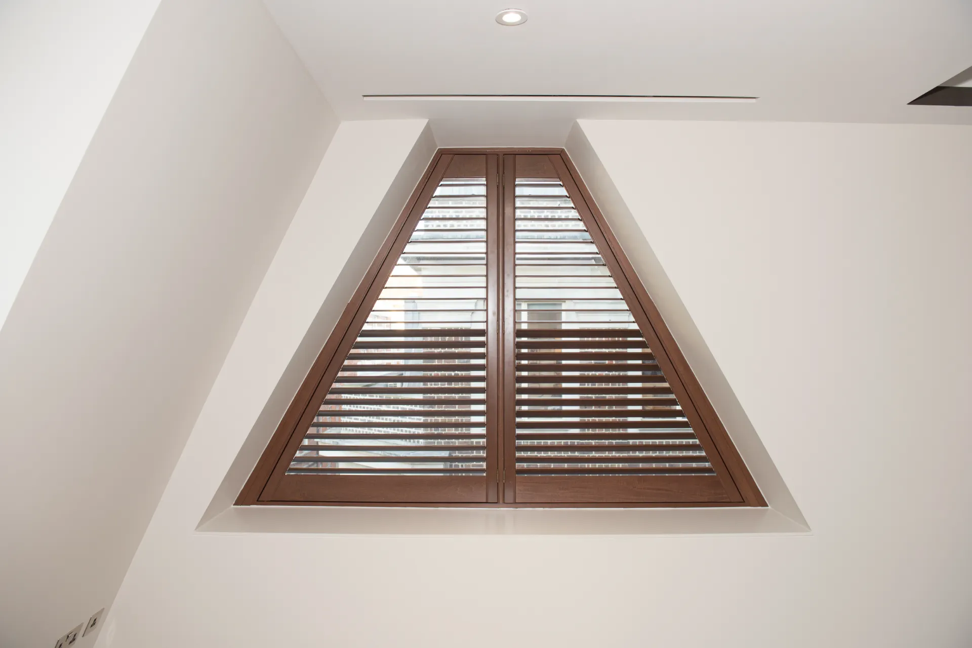triangular plantation shutters in a walnut stained colour